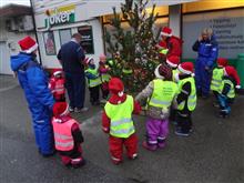 Nisseborn på besøk til butikken. Står rundt juletreet ute saman med kjøpmannen. - Klikk for stort bilete